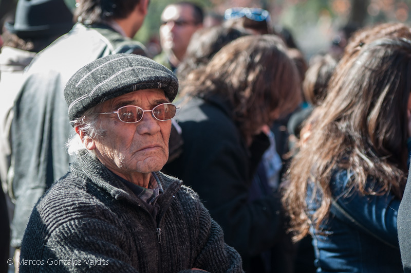 hombre adulto mayor sentado entre el público