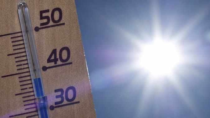 Foto del sol y termómetro midiendo la temperatura