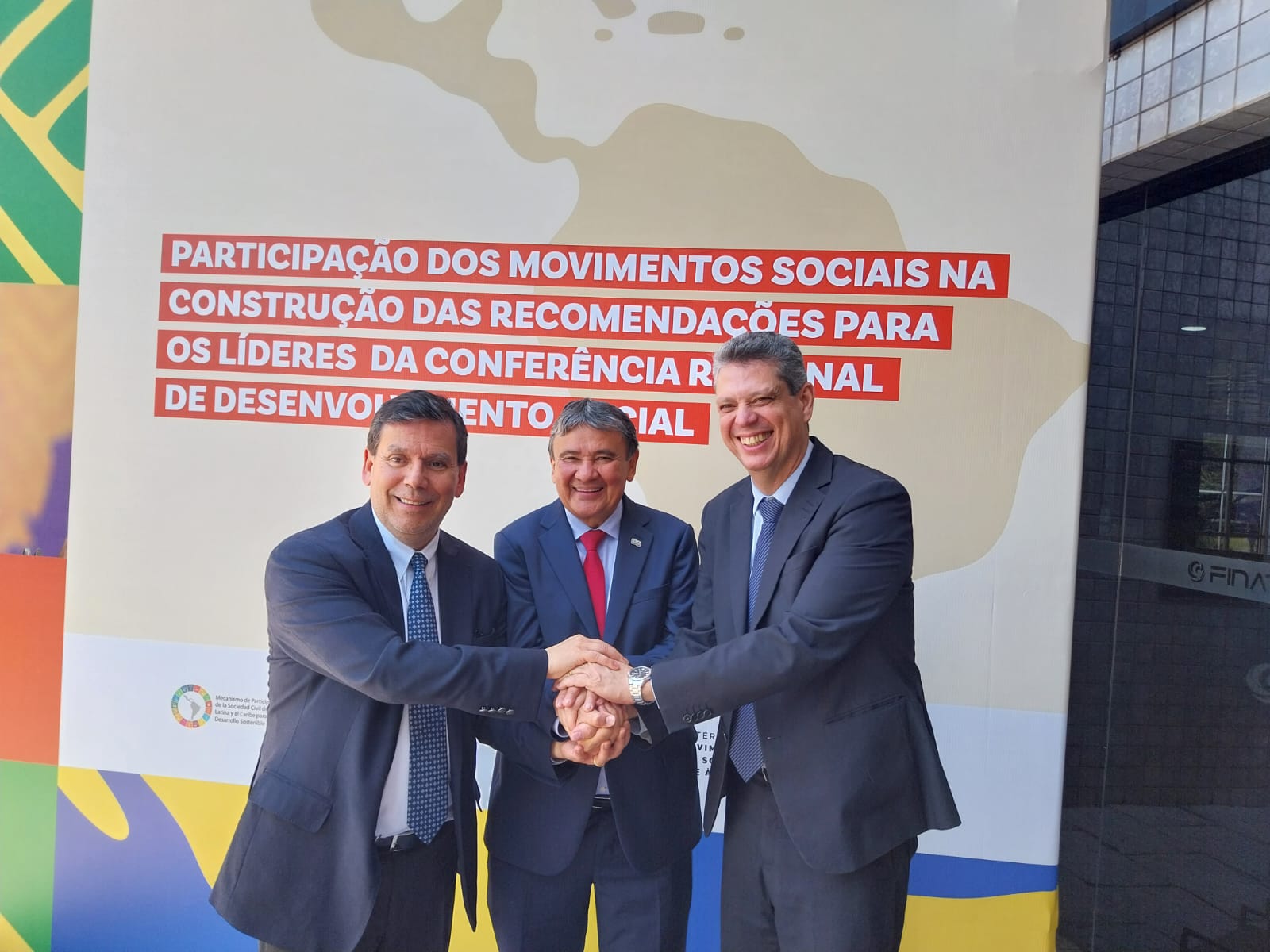tres señores dándose la mano