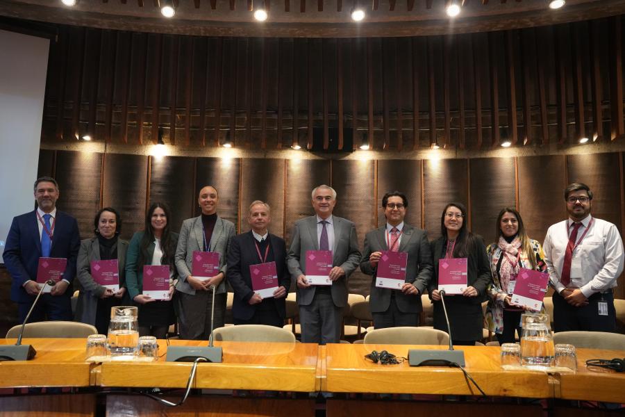 Grupo de personas sosteniendo una publicación de la CEPAL
